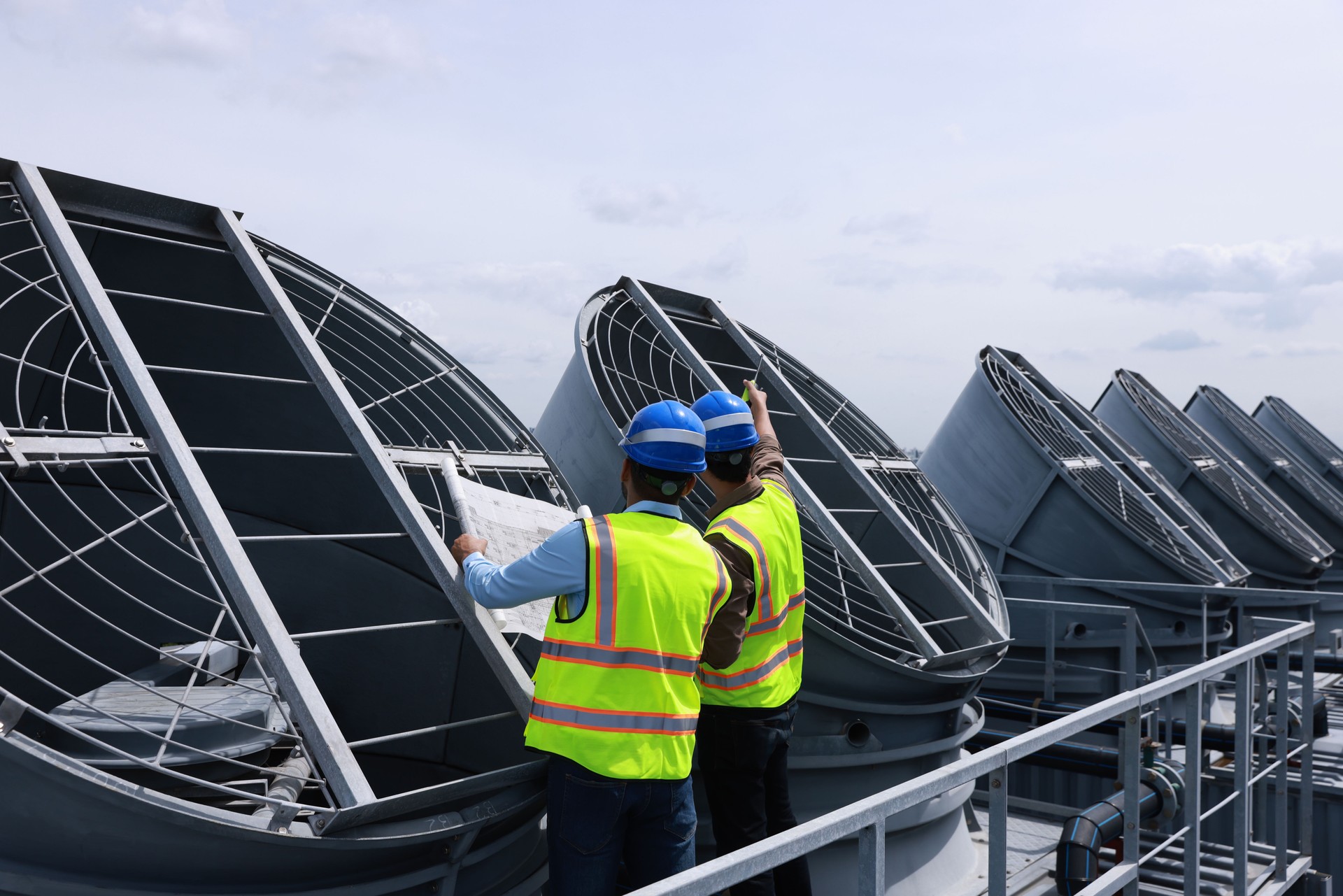 Mechanical engineer or industrial engineer with safety PPE inspect and maintenance cooling tower of HVAC system , Heating Ventilation and Air conditioning